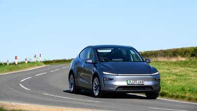 Tesla Model Y (2025) review: front three quarter driving, long lens, silver paint