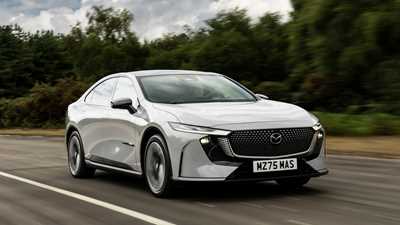 Mazda 6e (2026) review: front three quarter driving, grey paint, low angle
